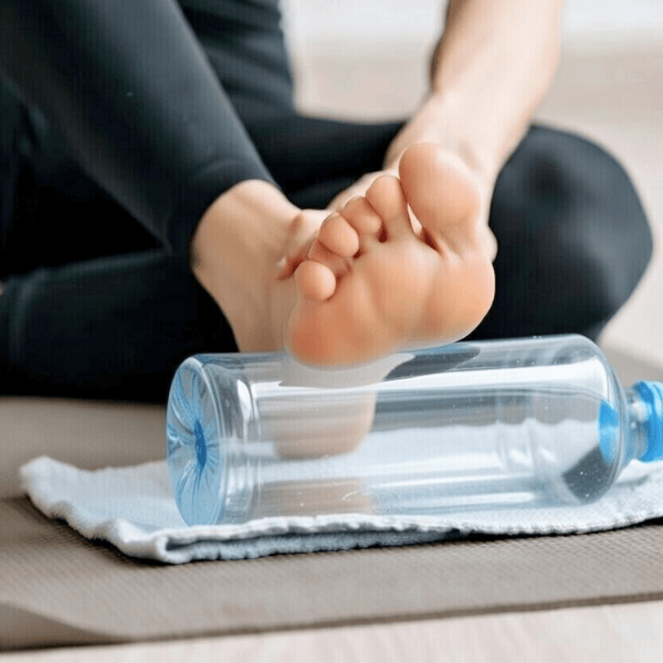 Person rolling foot on frozen water bottle for plantar fasciitis relief in Preston