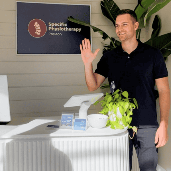 Physiotherapist welcoming patient at reception desk in Specific Physiotherapy Preston clinic
