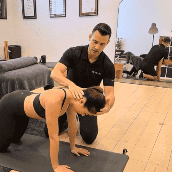 Physiotherapist guiding patient through neck and upper back rehabilitation exercise in clinic